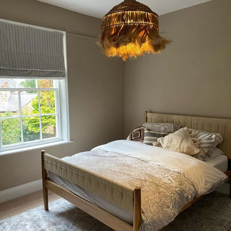 Спальная с люстрой из ротанга и бежевыми стенами