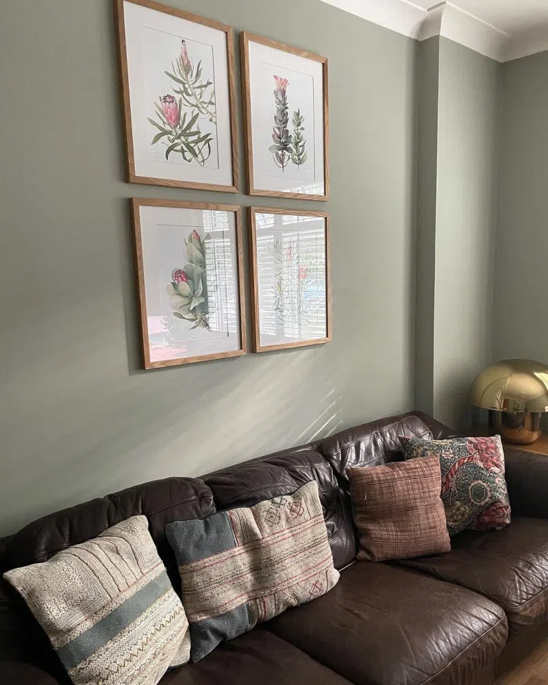 Гостиная с коричневым кожаным диваном и серыми стенами