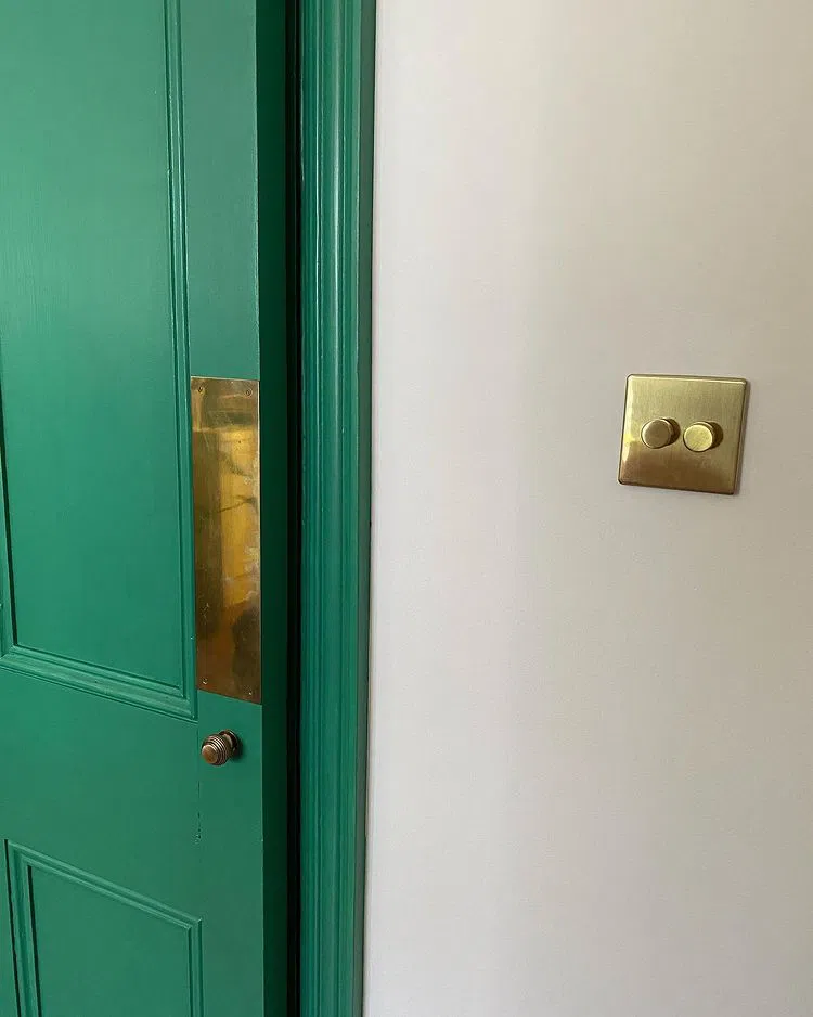 Золотистые винтажные выключатели в белыми стенами Flint