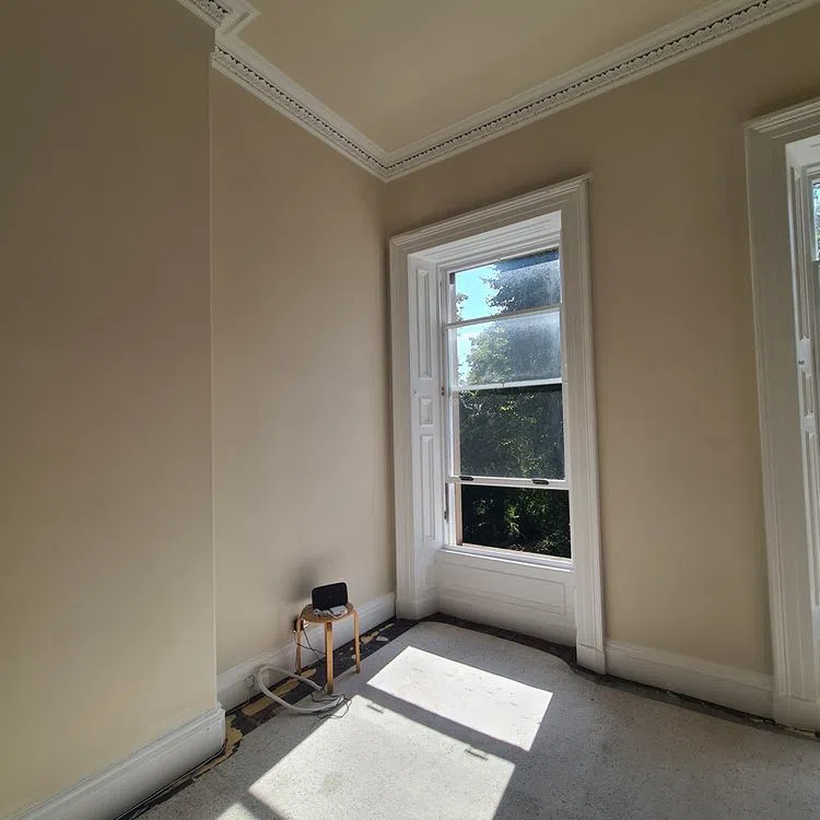 Интерьер с лепниной и высокими потолками и светлыми бежевыми стенами