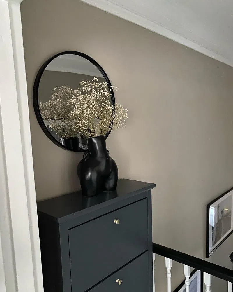 Бежевые стены Rolling Fog и черная ваза в виде женских бедер